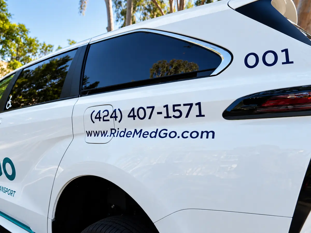 The MedGo Transportation phone number and website lettered on the side of the van.