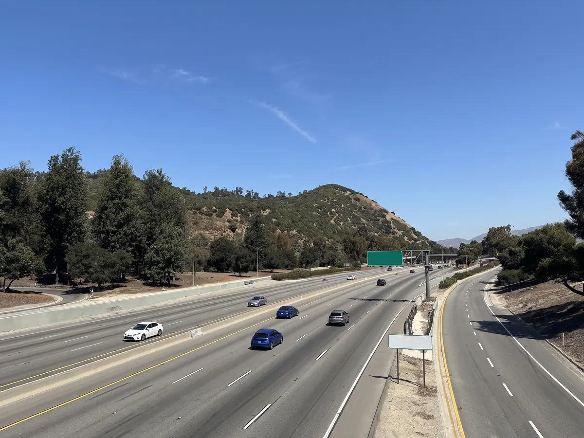 Light traffic on the Golden State Freeway heading out of Los Angeles, hills on both sides.